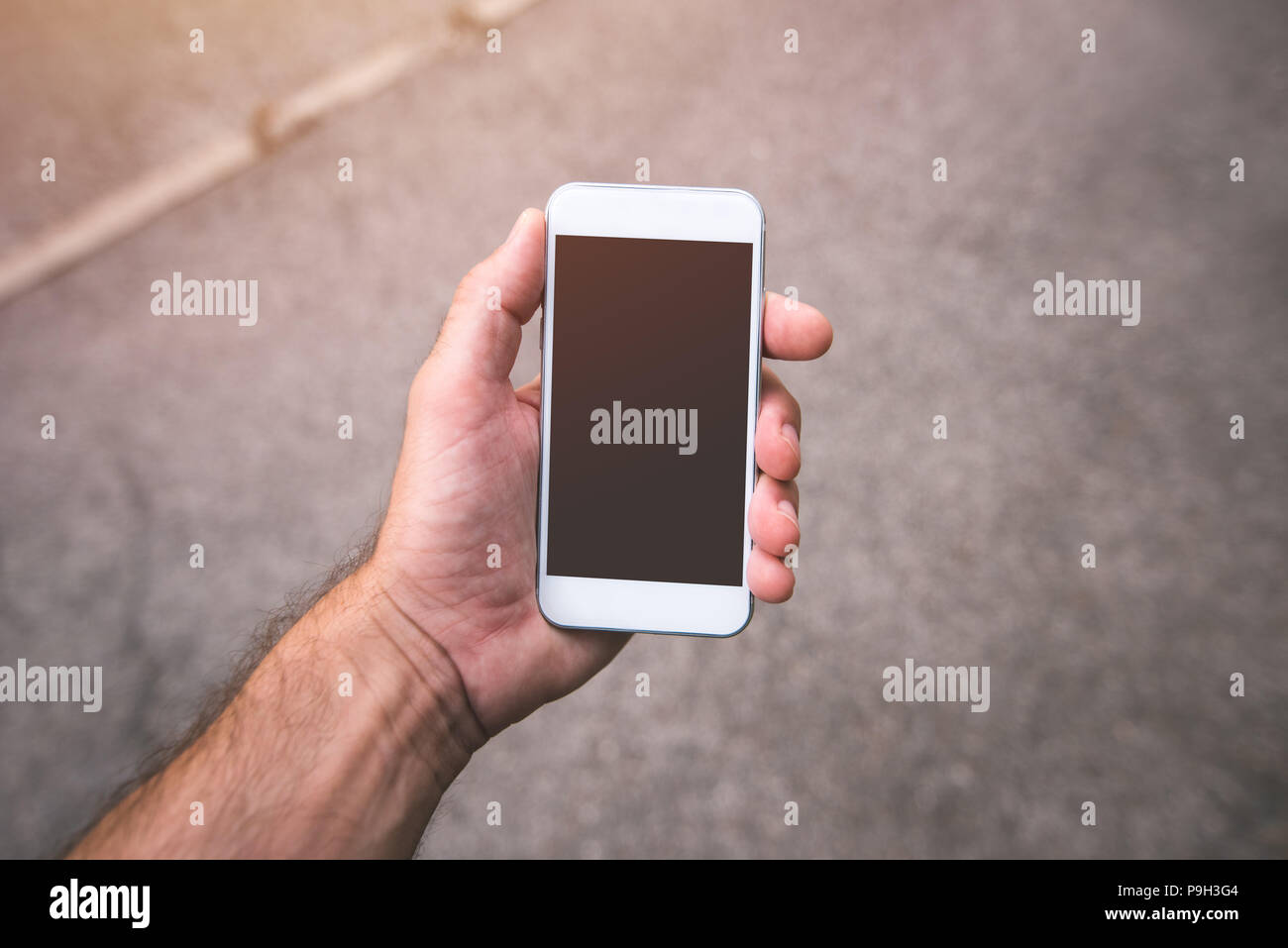 Hand mit Smartphone mock up kopieren, können Sie über ein modernes Handy auf der Straße im städtischen Umfeld Mann Stockfoto