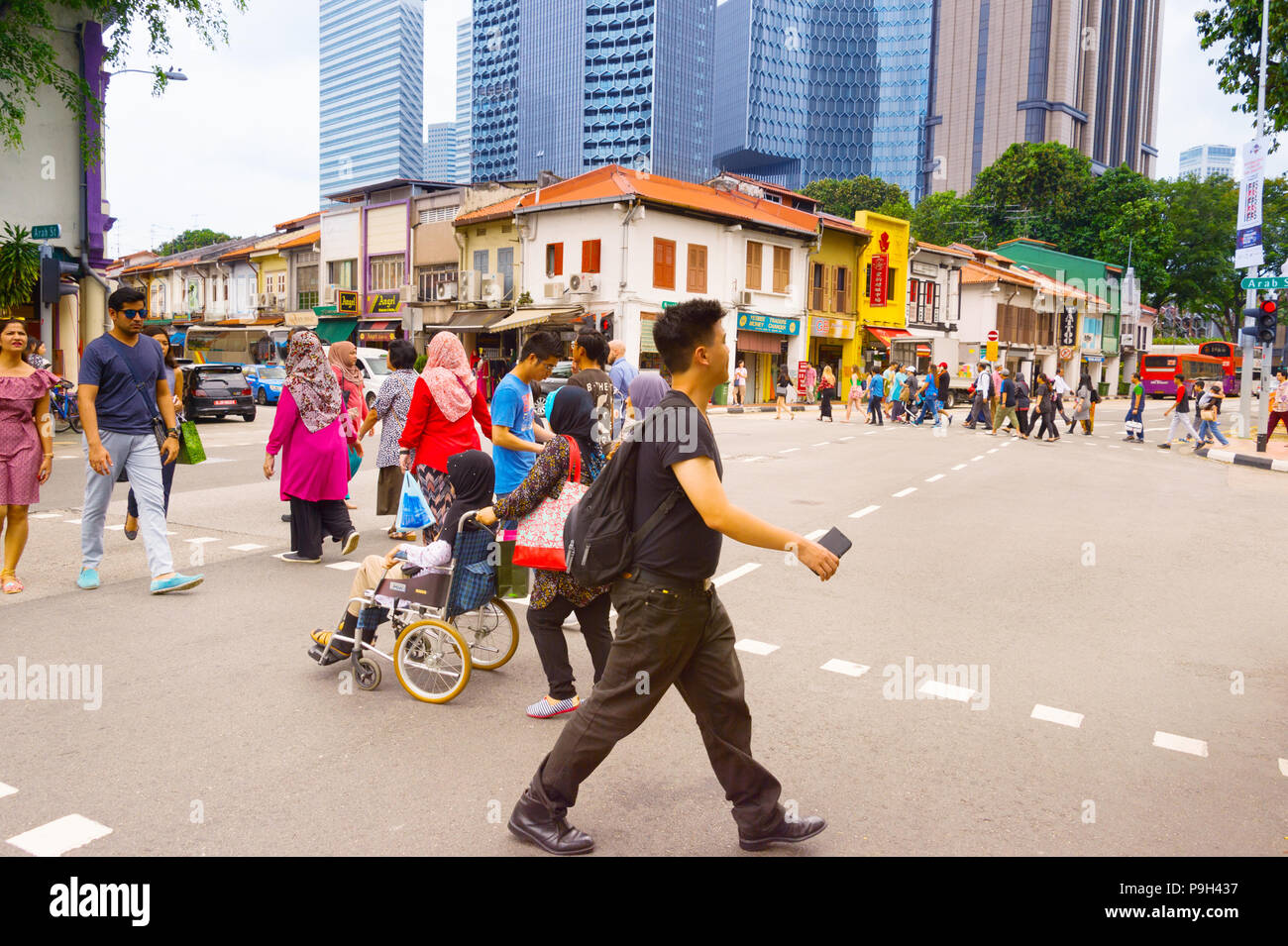 Singapur - 17. Februar 2017: Menschen beim Überqueren der Straße in Chinatown von Singapur. Moderne Wolkenkratzer von Downtown Singapur auf einem Hintergrund. Stockfoto