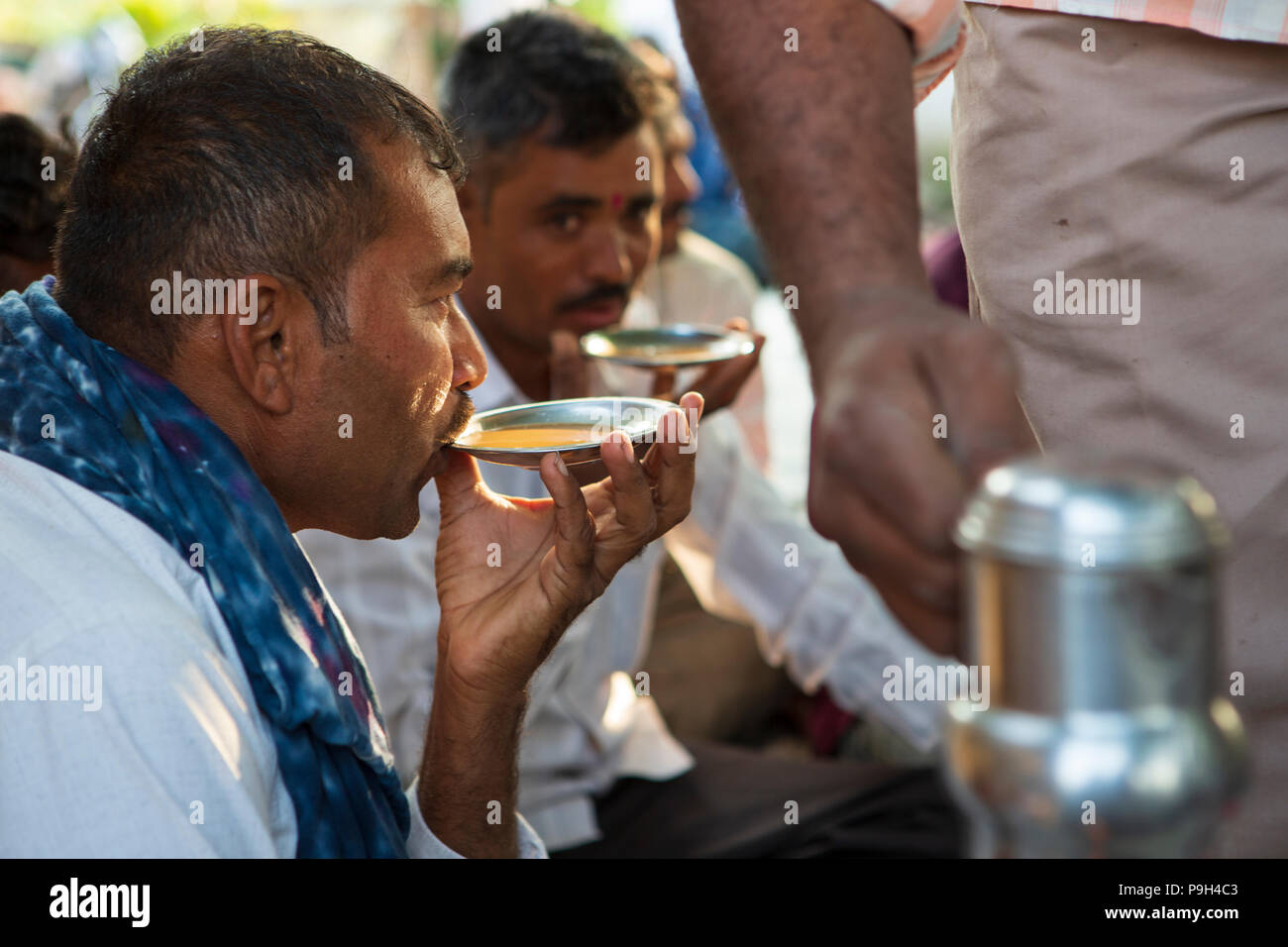 Ein Landwirt drinks Chai, während sich seine lokalen Bauern Interest Group. Stockfoto