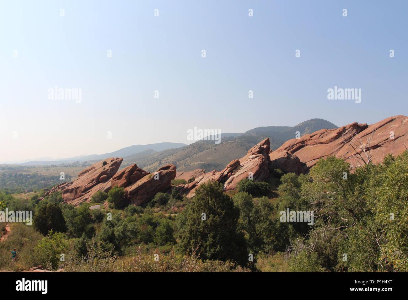 Große rote Felsformationen, ragt aus dem Boden, hinter Bäumen und Gräsern, auf der Trading Post Trail in Red Rocks State Park, Colorado, USA, mit Stockfoto