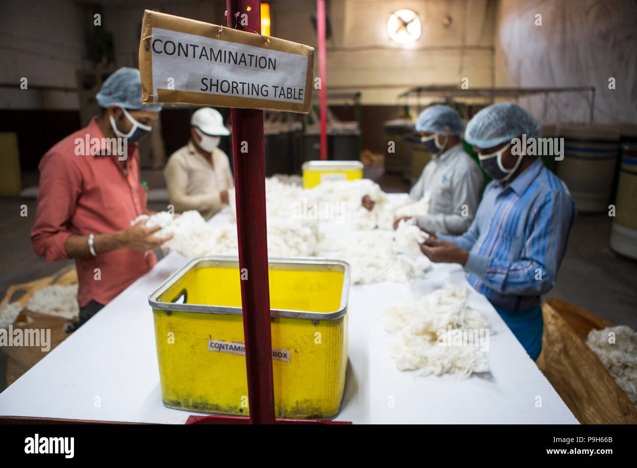 Menschen auf die Kontamination Sortierung Tabelle in einer Textilfabrik in Indore, Indien arbeiten. Stockfoto