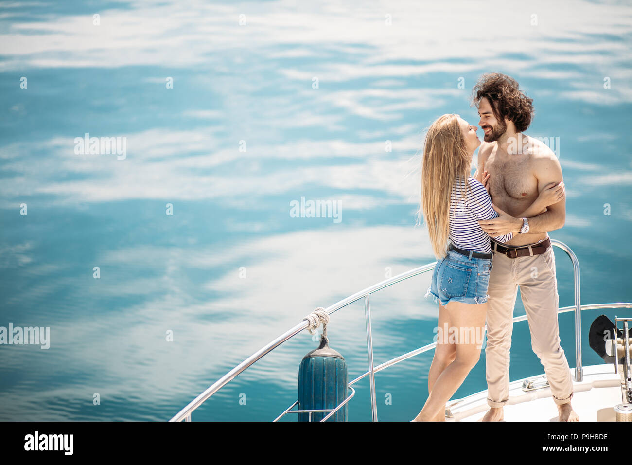 Leidenschaftlich liebende kaukasischen Paar tanzen auf Bogen Segelboot, über blaue Meer Hintergrund mit Copyspace. Sommer Urlaub, Menschen, Beziehungen und Liebe, Ro Stockfoto
