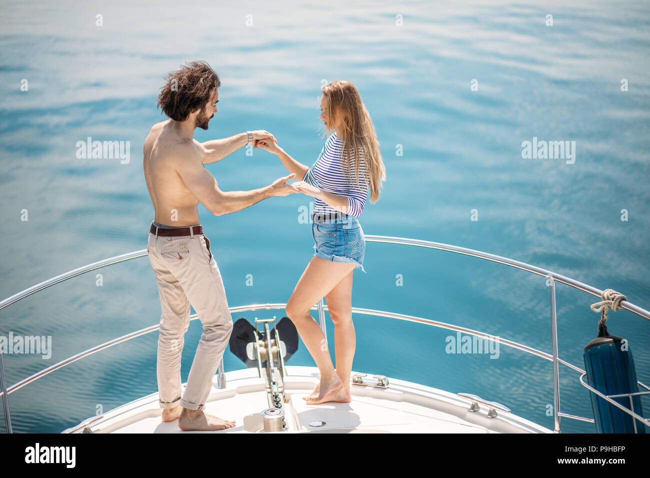 Leidenschaftlich liebende kaukasischen Paar tanzen auf Bogen Segelboot, über blaue Meer Hintergrund mit Copyspace. Sommer Urlaub, Menschen, Beziehungen und Liebe, Ro Stockfoto