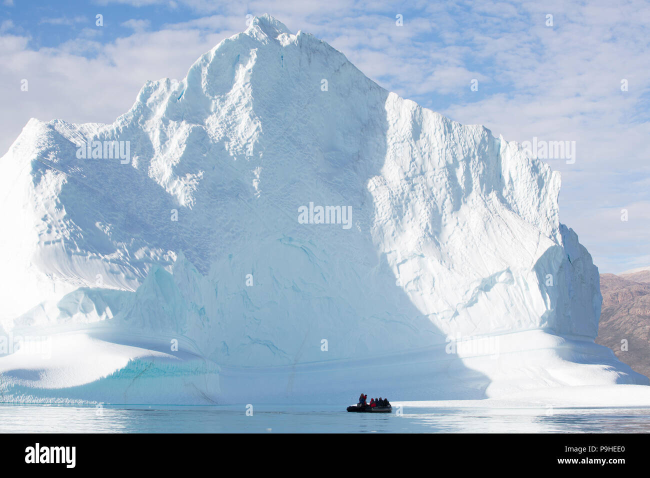 Zodiacs füllen mit Touristen Schwimmer unter enormen Eisberge in Scoresby-sund, Grönland Stockfoto