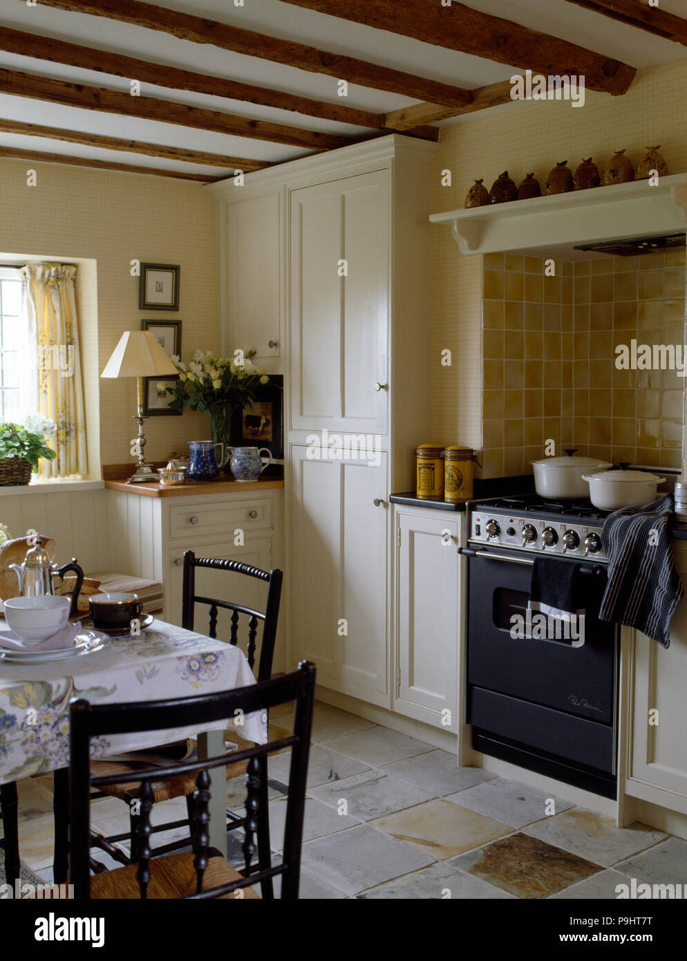 Angebot Backofen in einer Creme Land Küche mit bemalten Stühle Tisch für  Frühstück Stockfotografie - Alamy