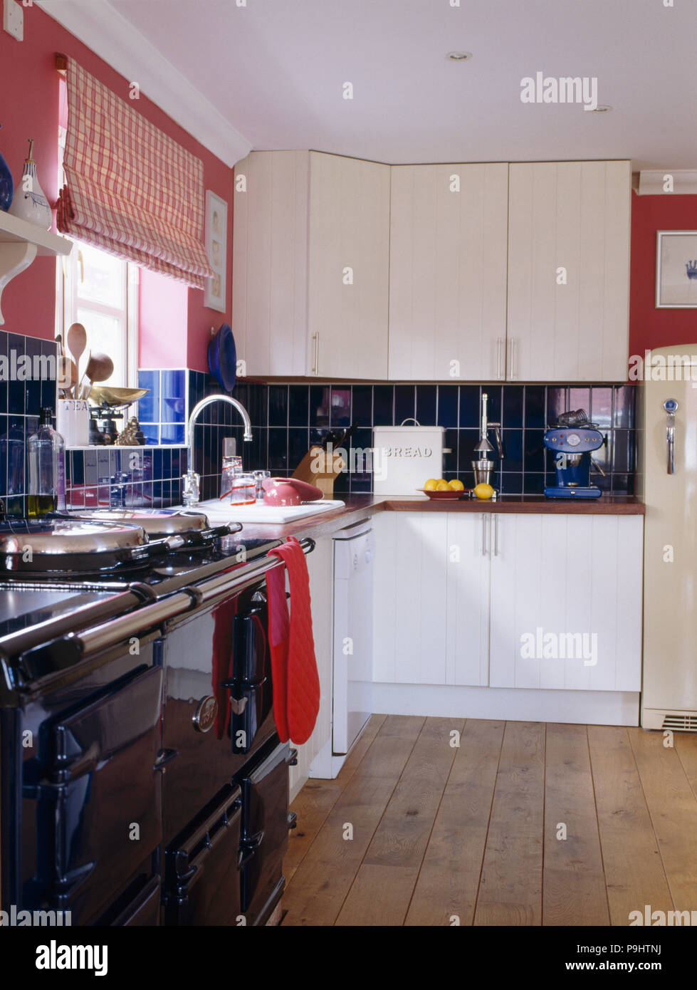 Holzböden in Land Küche ausgestattet mit weißen und schwarzen Aga Backofen Stockfoto