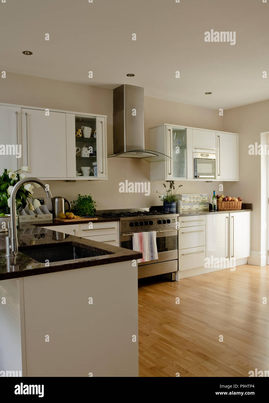 Holzböden in modernen beigefarbenen Küche ausgestattet mit weiße Einheiten Stockfoto
