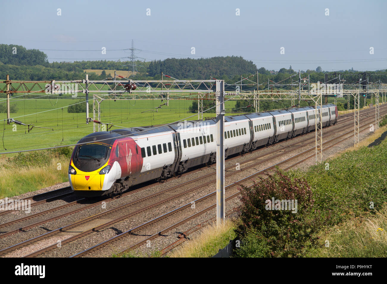 Eine Klasse 390 Pendolino Nummer 390016 in einer überarbeiteten Jungfrau livery Arbeiten ein Virgin Trains Westküste service Ledburn Kreuzung am 30. Juni 2018. Stockfoto