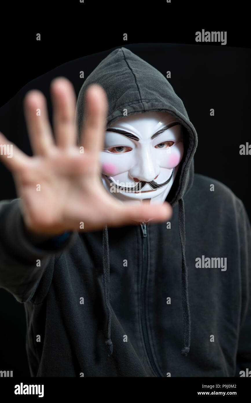 Anonyme hacker trägt eine Guy Fawkes Maske und ein Schwarzer Hoodie Stockfoto