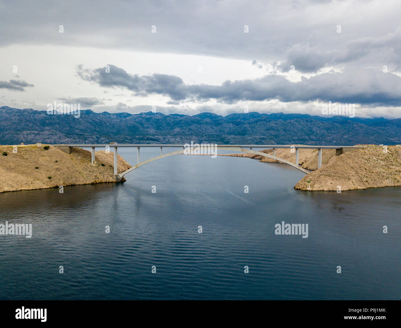 Luftaufnahme der Brücke von der Insel Pag, Kroatien, Straßen und der kroatischen Küste. Klippe mit Blick auf das Meer. Autos über die Brücke von oben gesehen Stockfoto