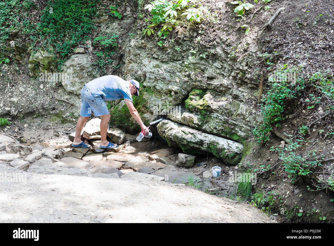 SHAPSUGSKAYA, Russland - Juli 5, 2018: man füllt botle von Silver Spring (Quelle von Lebenden und Toten Wasser) in Shapsugskaya anomale Zone in Abinsk Foo Stockfoto