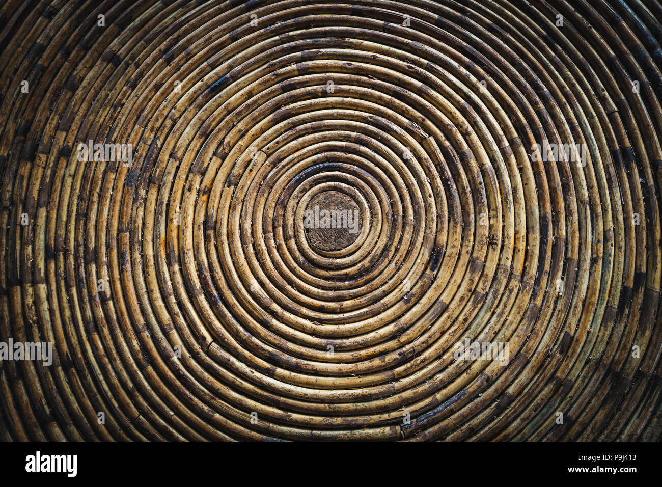 Kreisförmige Textur einer Bambus Schüssel. Unter einem bambusdach. in eine Spirale aus Bambus verdreht Stockfoto