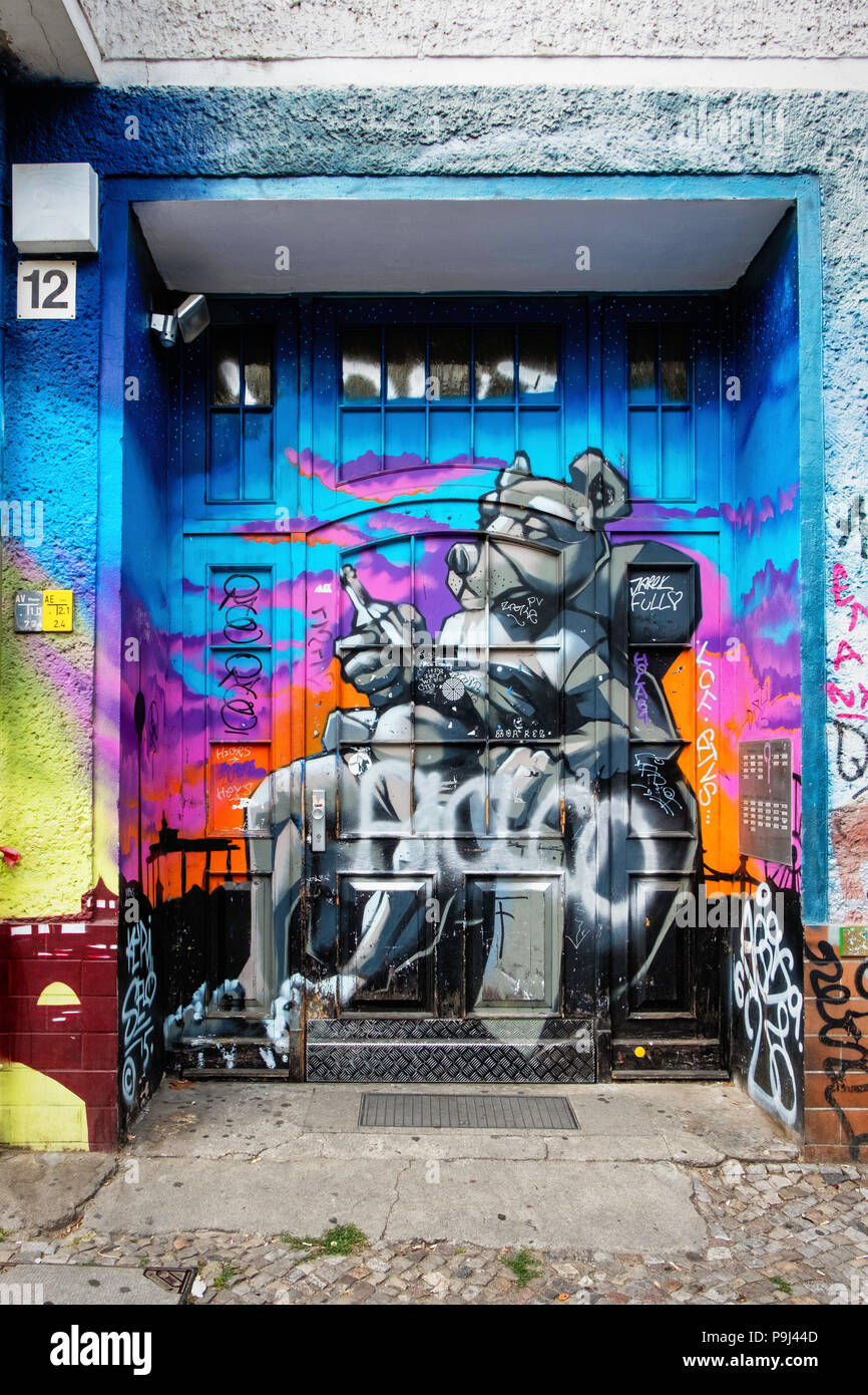 Berlin, Friedrichshain, Revaler Str. hölzerne Tür verschwindet hinter bunten Street Art sitzende Bär Flasche hält Stockfoto