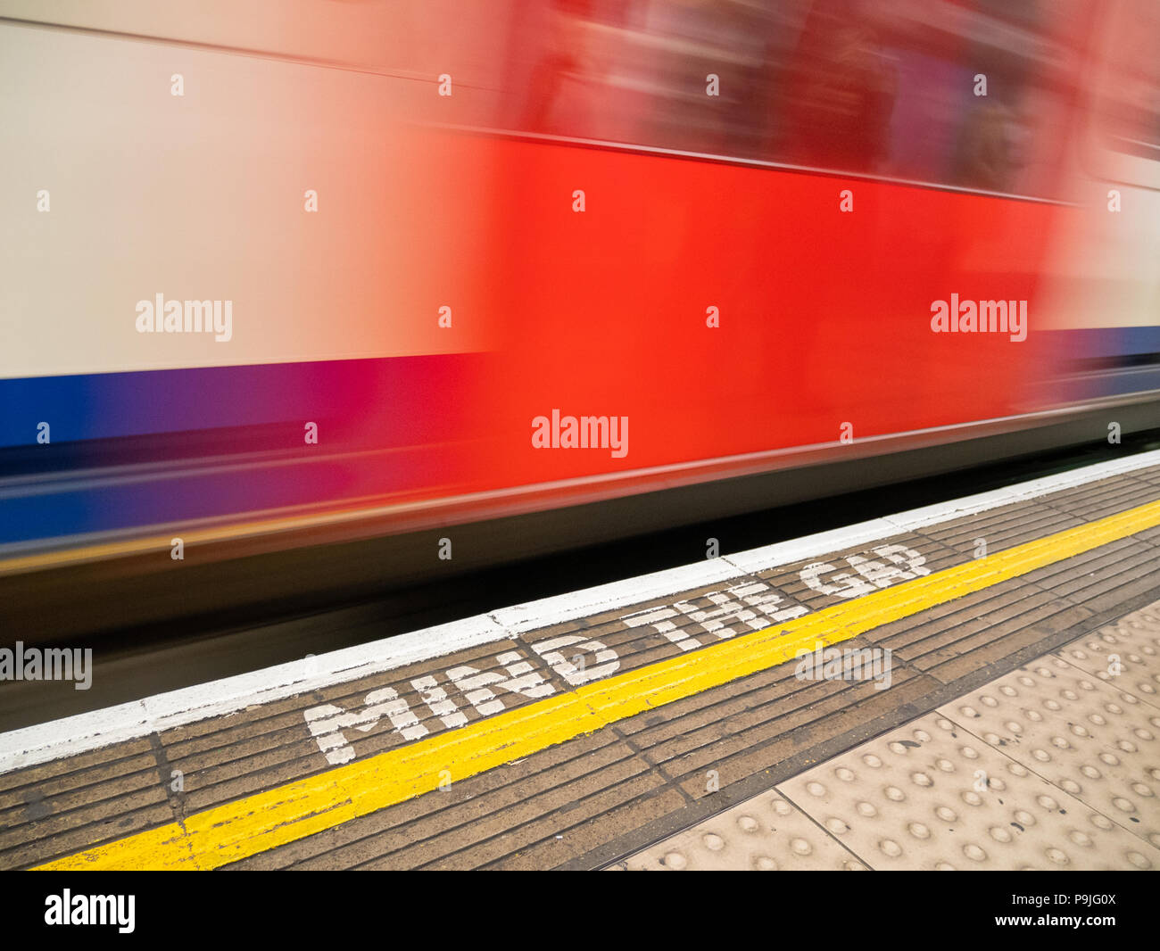 Unschärfe der Londoner U-Bahn und Mind The Gap Warnschild an Bahnsteigkante, London, UK Stockfoto