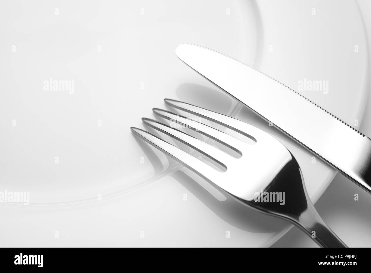 Messer und Gabel auf einem leeren Teller, Besteck und Kopieren, auf weißem Hintergrund Stockfoto