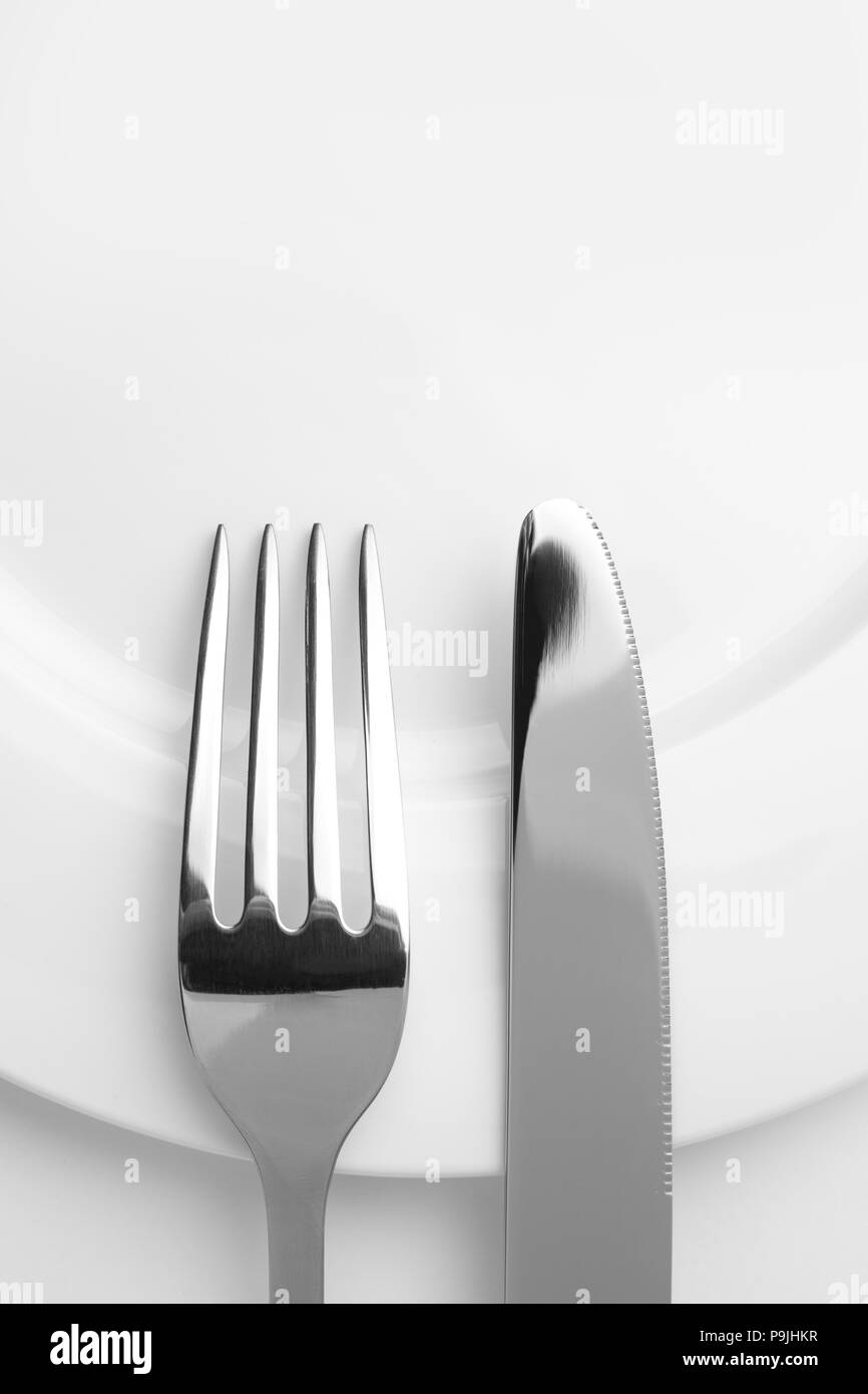 Messer und Gabel auf einem leeren Teller, Besteck und Kopieren, auf weißem Hintergrund Stockfoto