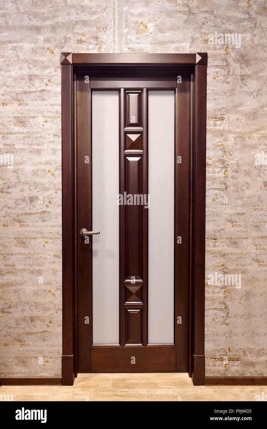 Braun Metall mit Holz- overlays Eingangstür mit Messing-griff und Frosted matt Glas mit Stock in Beigetönen Fliesen- Stockfoto