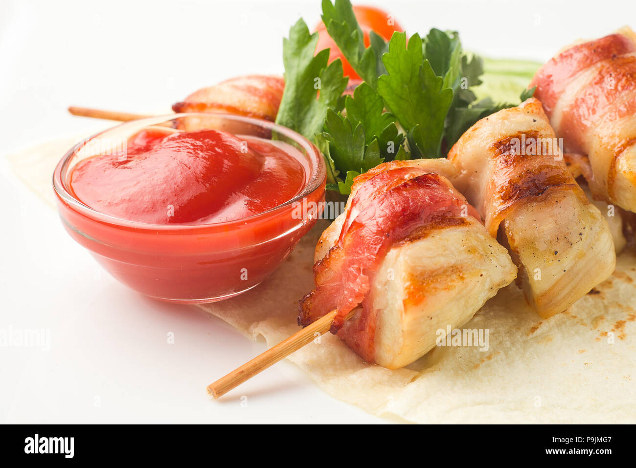 Hähnchen am Spieß, gebacken in Speck, beruht auf einer Pita mit cucumb Stockfoto