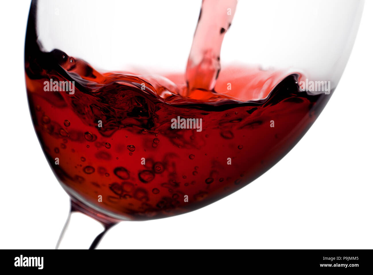 Rotwein gegossen aus einer Flasche in Weinglas auf weißem Hintergrund Stockfoto