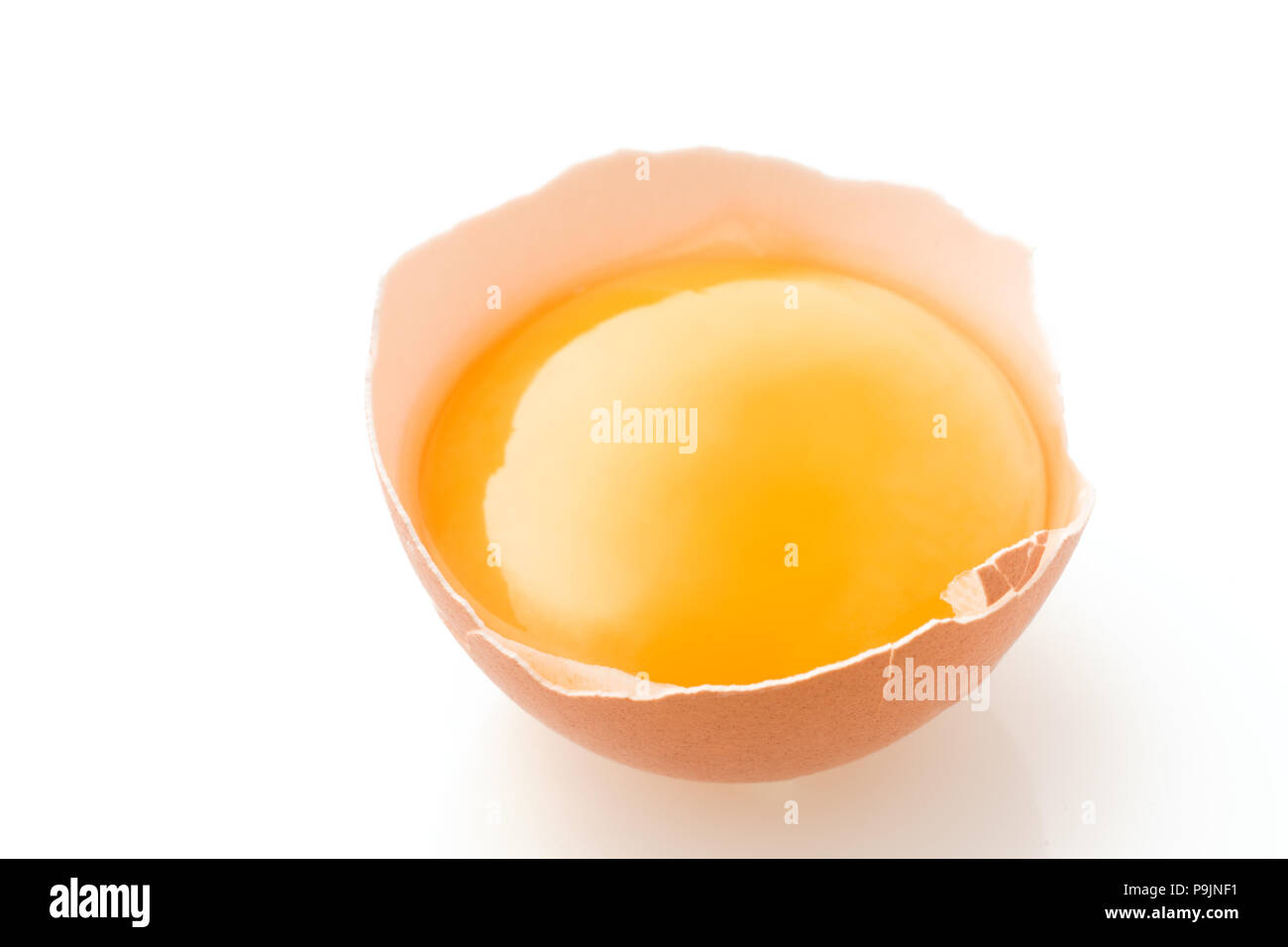 Gebrochene Huhn Ei liegt auf einem weißen Hintergrund mit einer Schale, Eigelb und verschüttete Protein, isoliert Stockfoto