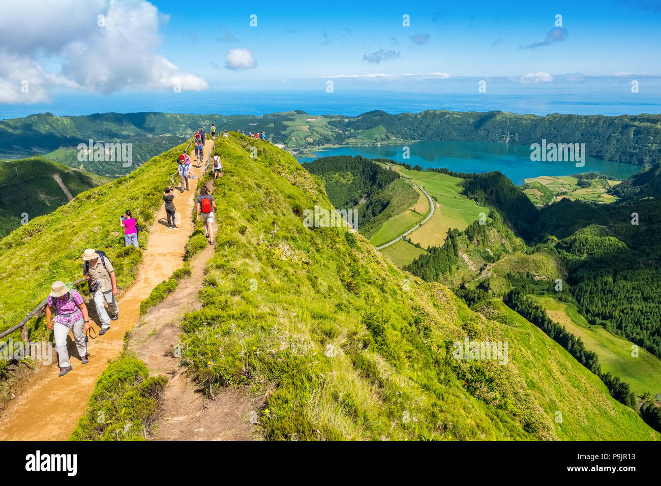 Touristen an einem Aussichtspunkt über Sete Cidades, zwei Seen und ein Dorf in der ruhenden Krater eines Vulkans auf der Insel Sao Miguel, Azoren Stockfoto