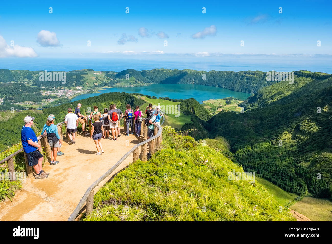 Touristen an einem Aussichtspunkt über Sete Cidades, zwei Seen und ein Dorf in der ruhenden Krater eines Vulkans auf der Insel Sao Miguel, Azoren Stockfoto