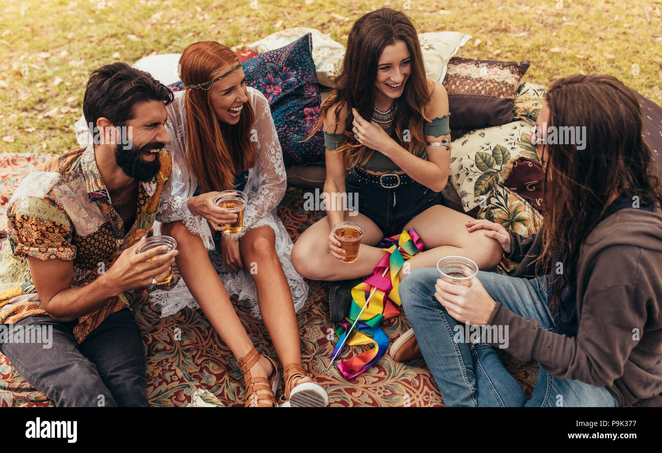 Lächelnden jungen Freunde heraus hängen mit Bieren an Music Festival. Eine Gruppe von Freunden im Park sitzen und Spaß haben. Stockfoto