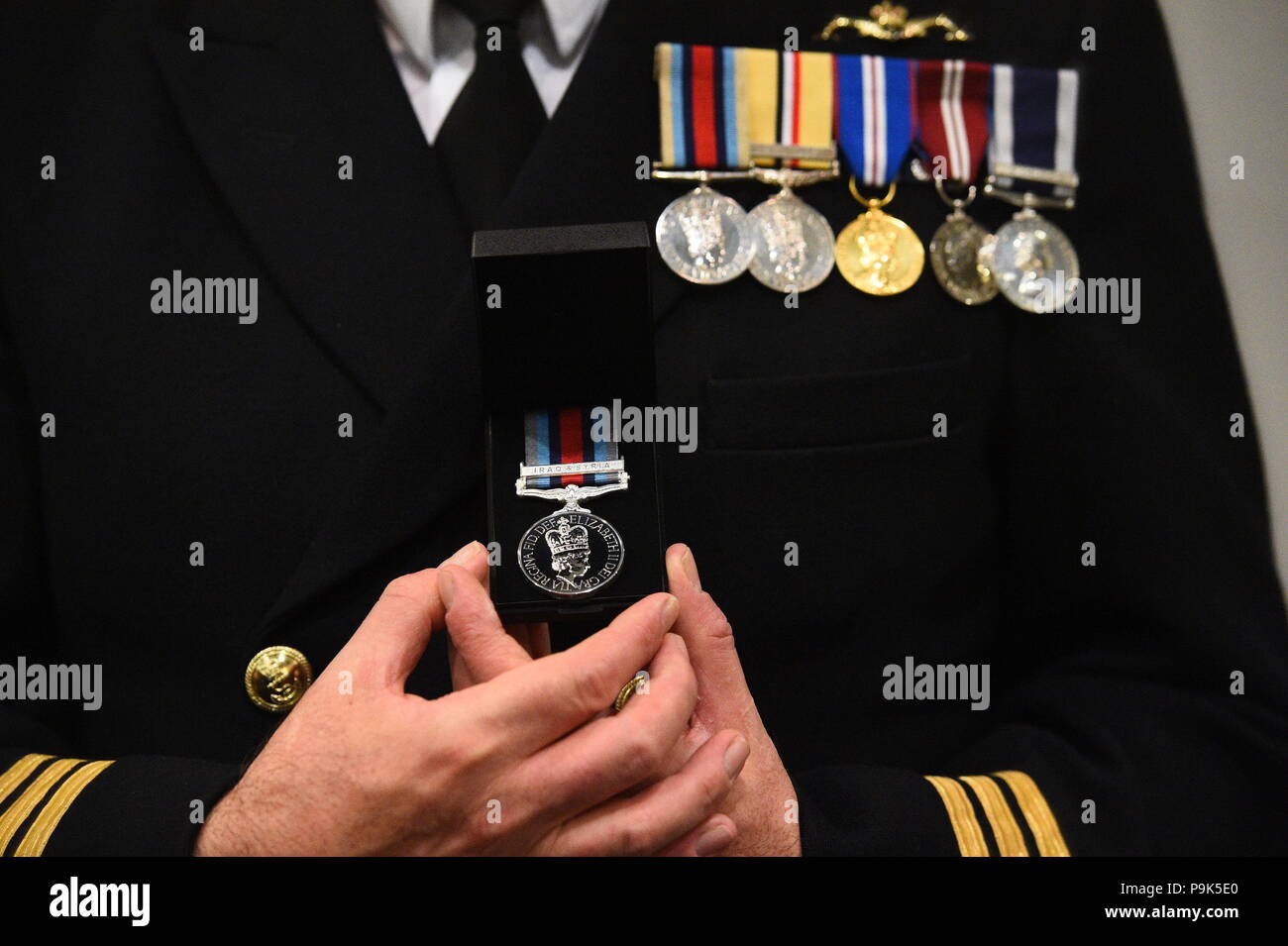 Ein Veteran hält seinen neuen Betrieb Shader Medaille, die ihm die Beteiligung an der Koalition Kampf gegen Daesh im Irak und in Syrien vorgelegt wurde, auf das Verteidigungsministerium in London. Stockfoto