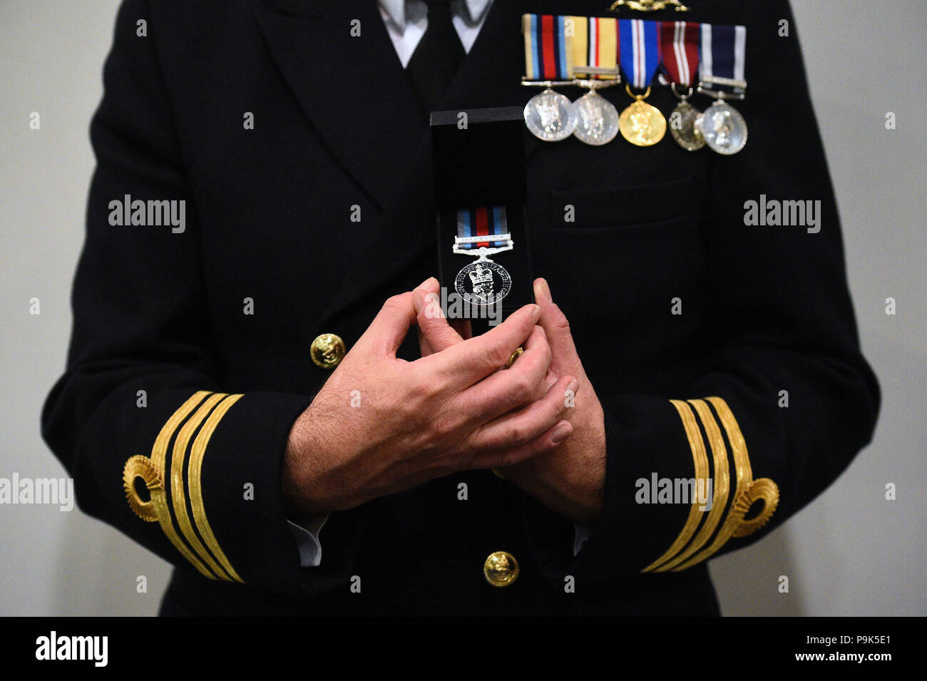 Ein Veteran hält seinen neuen Betrieb Shader Medaille, die ihm die Beteiligung an der Koalition Kampf gegen Daesh im Irak und in Syrien vorgelegt wurde, auf das Verteidigungsministerium in London. Stockfoto