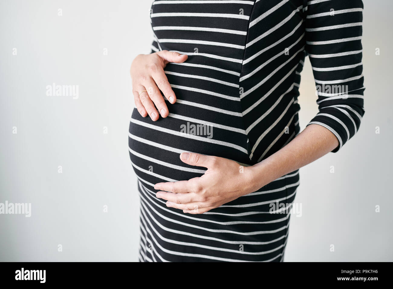 Schwangere Frau in gestreiften Kleid Stockfoto