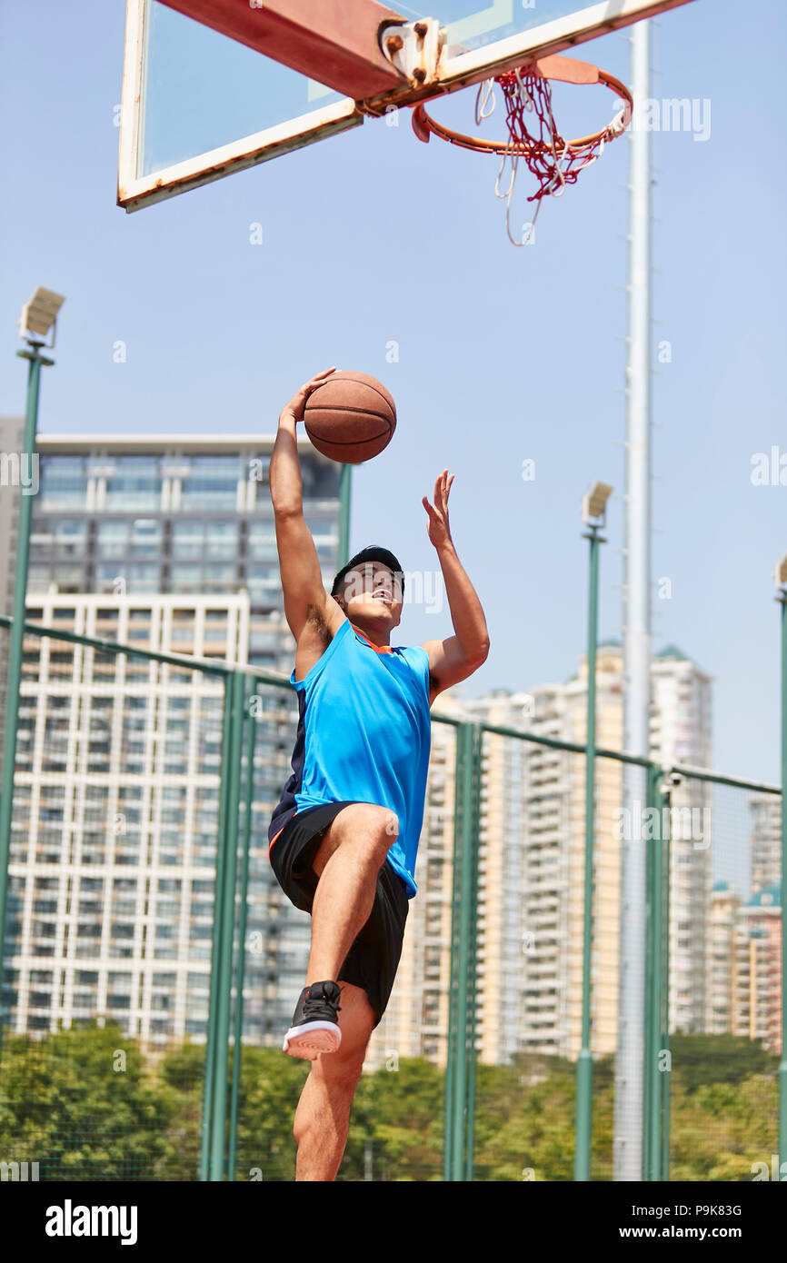 Jungen asiatischen männlicher Spieler spielen Basketball im Freien Gericht. Stockfoto
