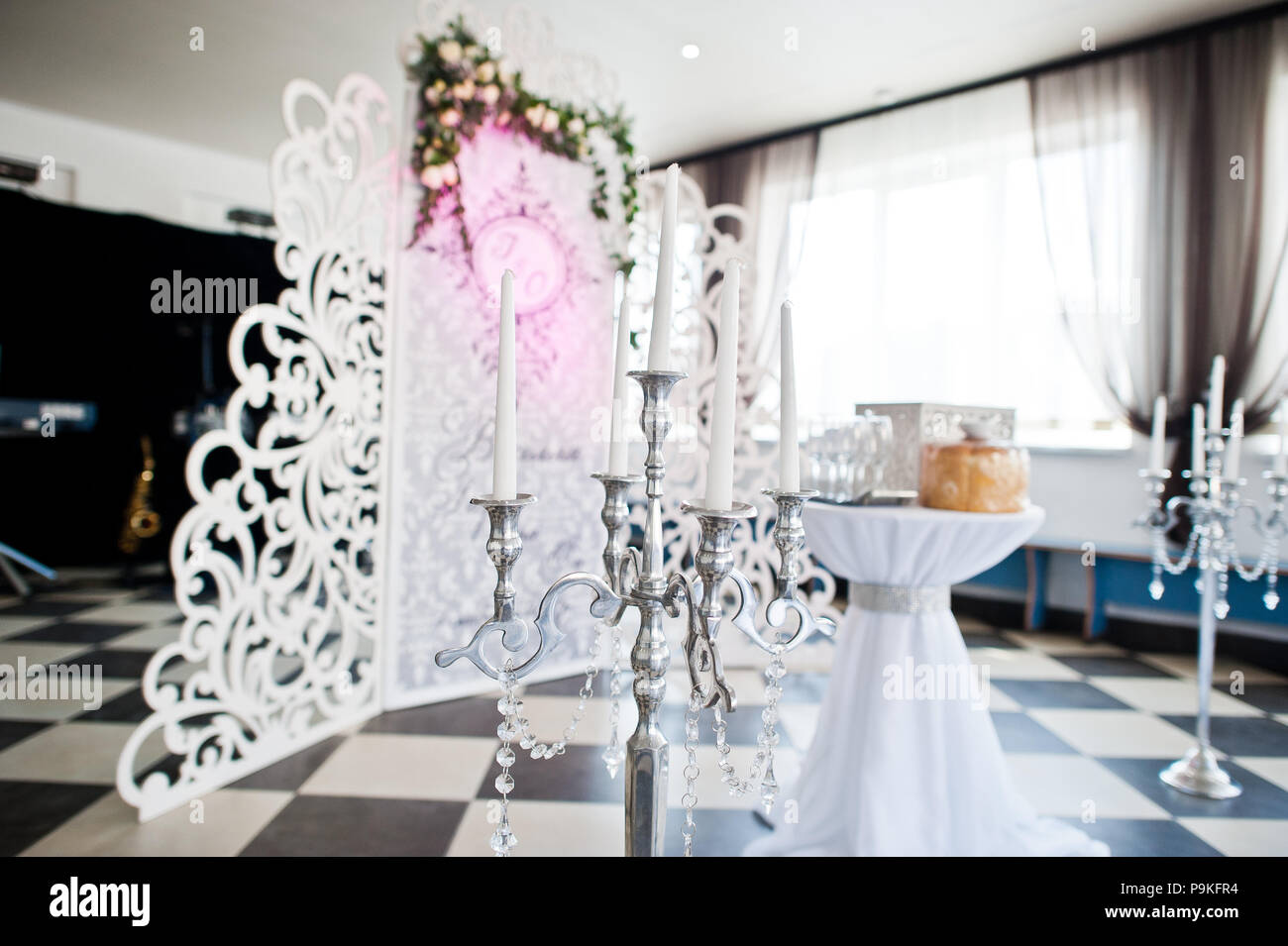 Besonderes Foto Zone mit kleinen hölzernen Wand mit Blumen und die Hochzeit paar Initialen verziert. Tabelle mit Box und Brot. Stockfoto