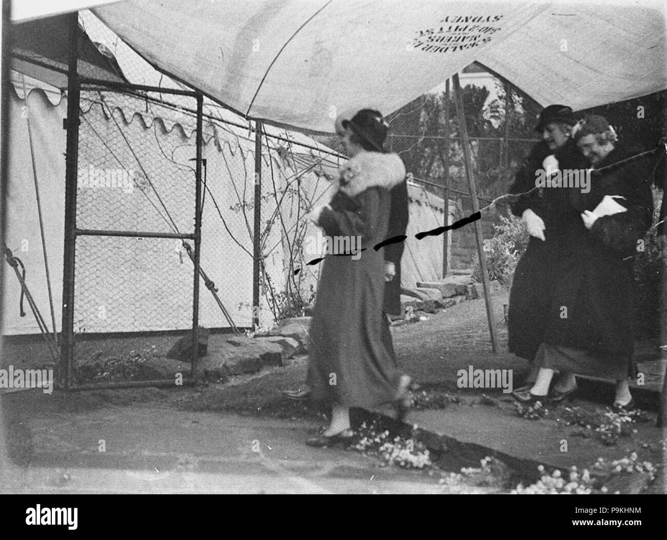 273 SLNSW 51897 Gäste kommen in Regen für WhitneyFriend Hochzeit Wirian geschützt durch ein Festzelt auf dem Tennisplatz von Sam Walder Sohn später geadelt Stockfoto