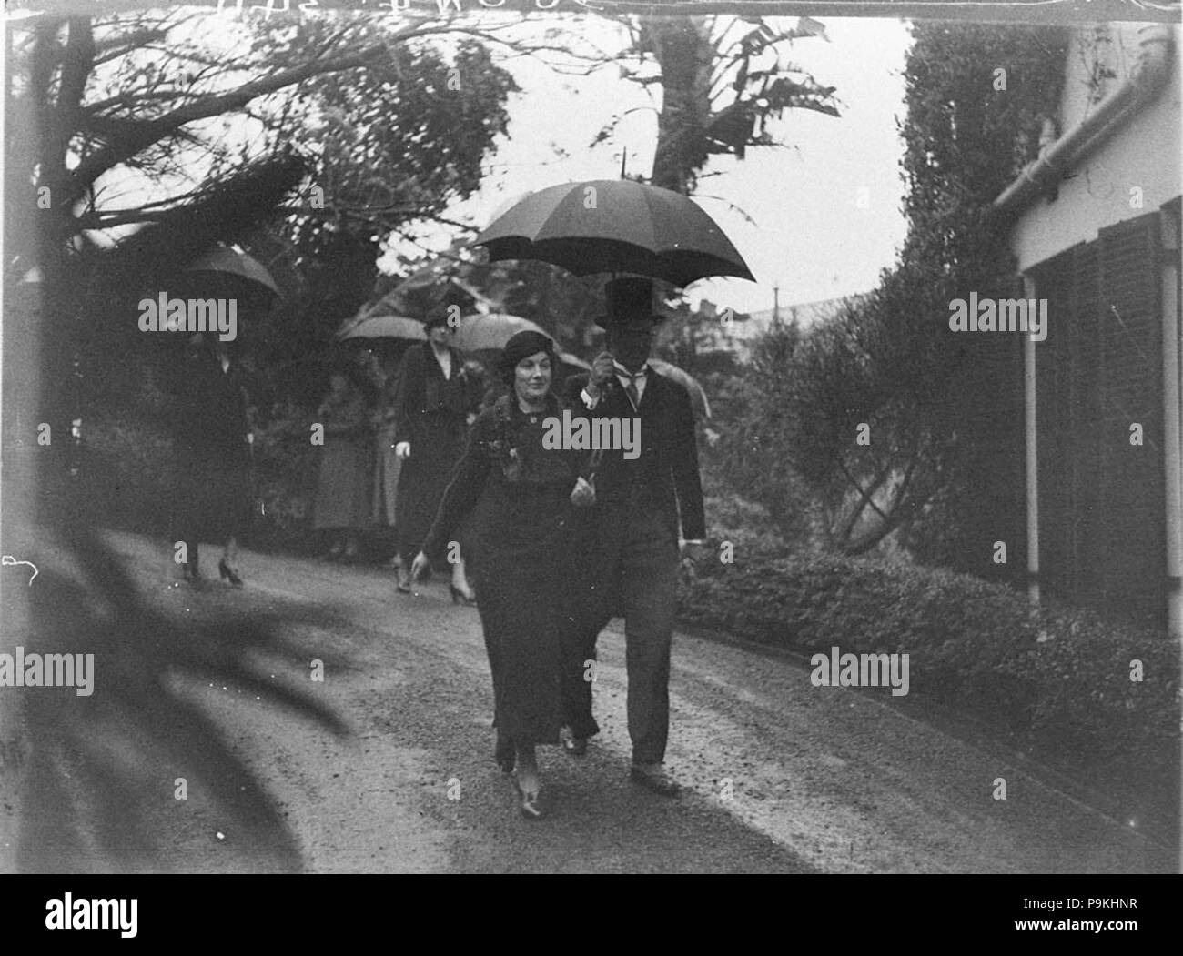 273 SLNSW 51904 Gäste kommen in Regen für WhitneyFriend Hochzeit Wirian Stockfoto