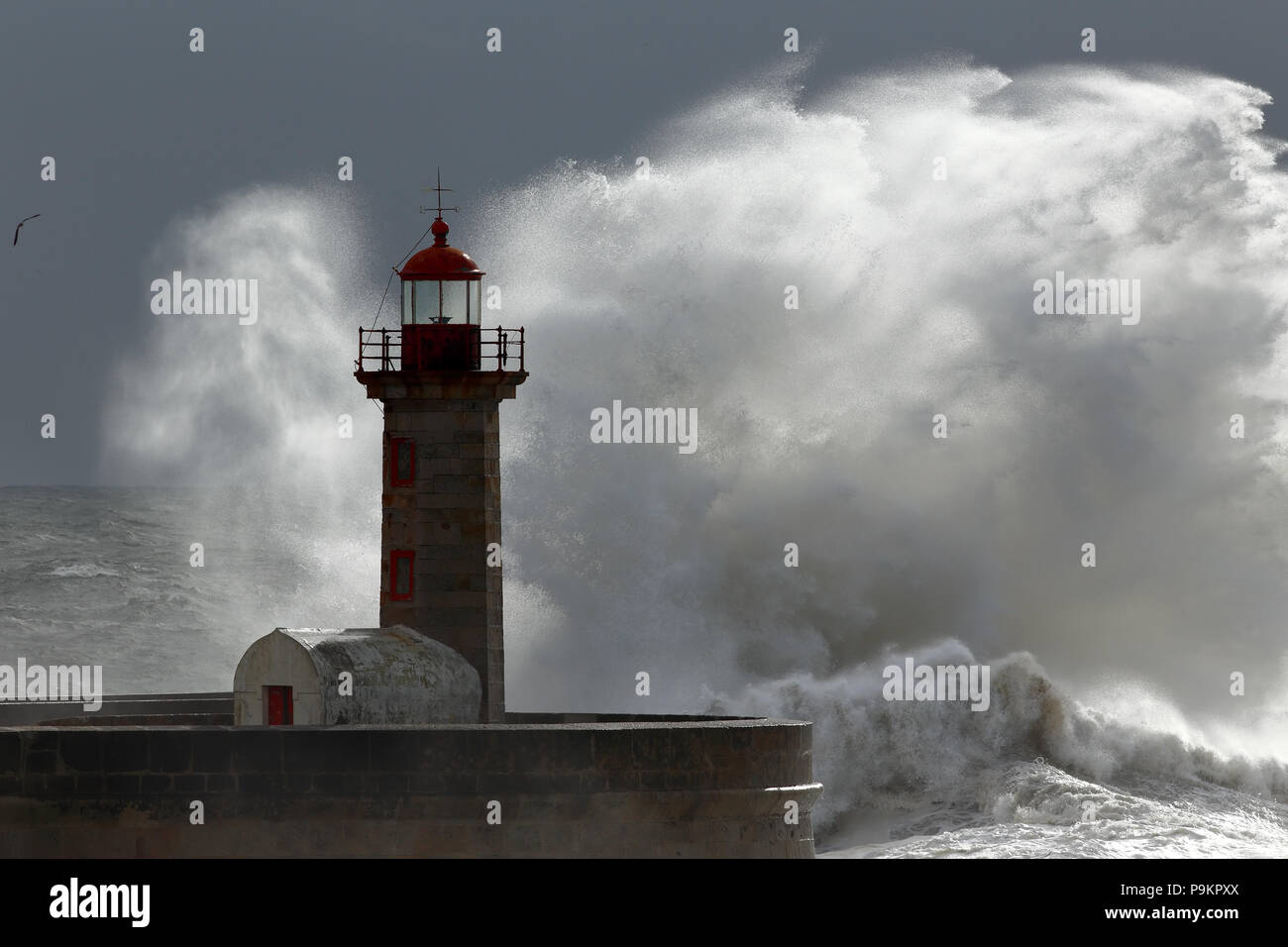 Big Wave über dem alten Leuchtturm, Porto, Portugal Stockfoto