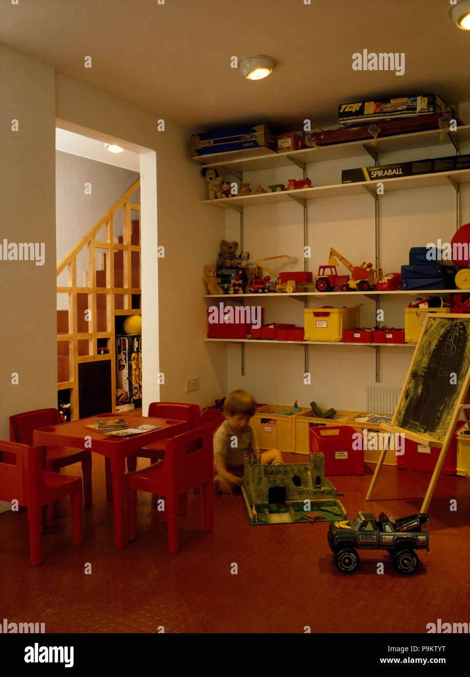 Kleiner Junge spielt in sechziger Jahre Spielzimmer Stockfoto