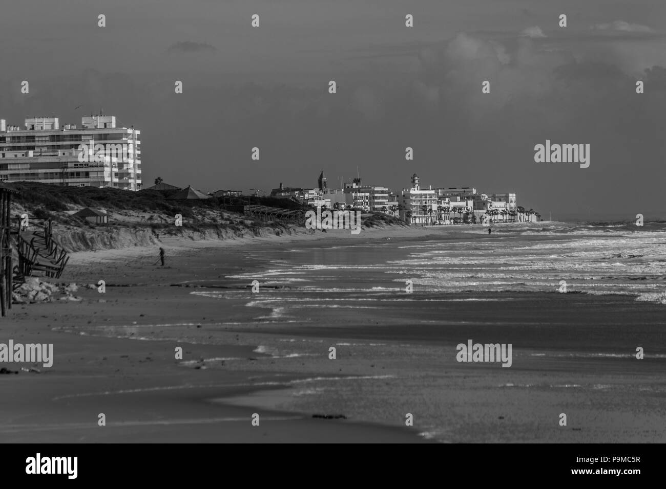 Spanisch Strand mit Bewohnern zu Fuß und der Stadt im Hintergrund Stockfoto