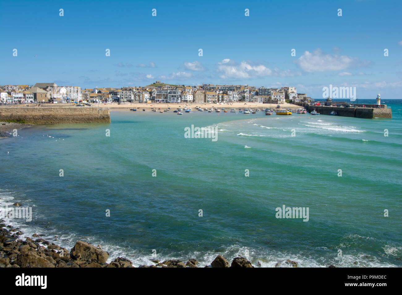 Blick auf den Hafen von St Ives in der Ferne mit ihren weißen Leuchtturm auf smeatons Pier, St Ives, Cornwall, Großbritannien Stockfoto