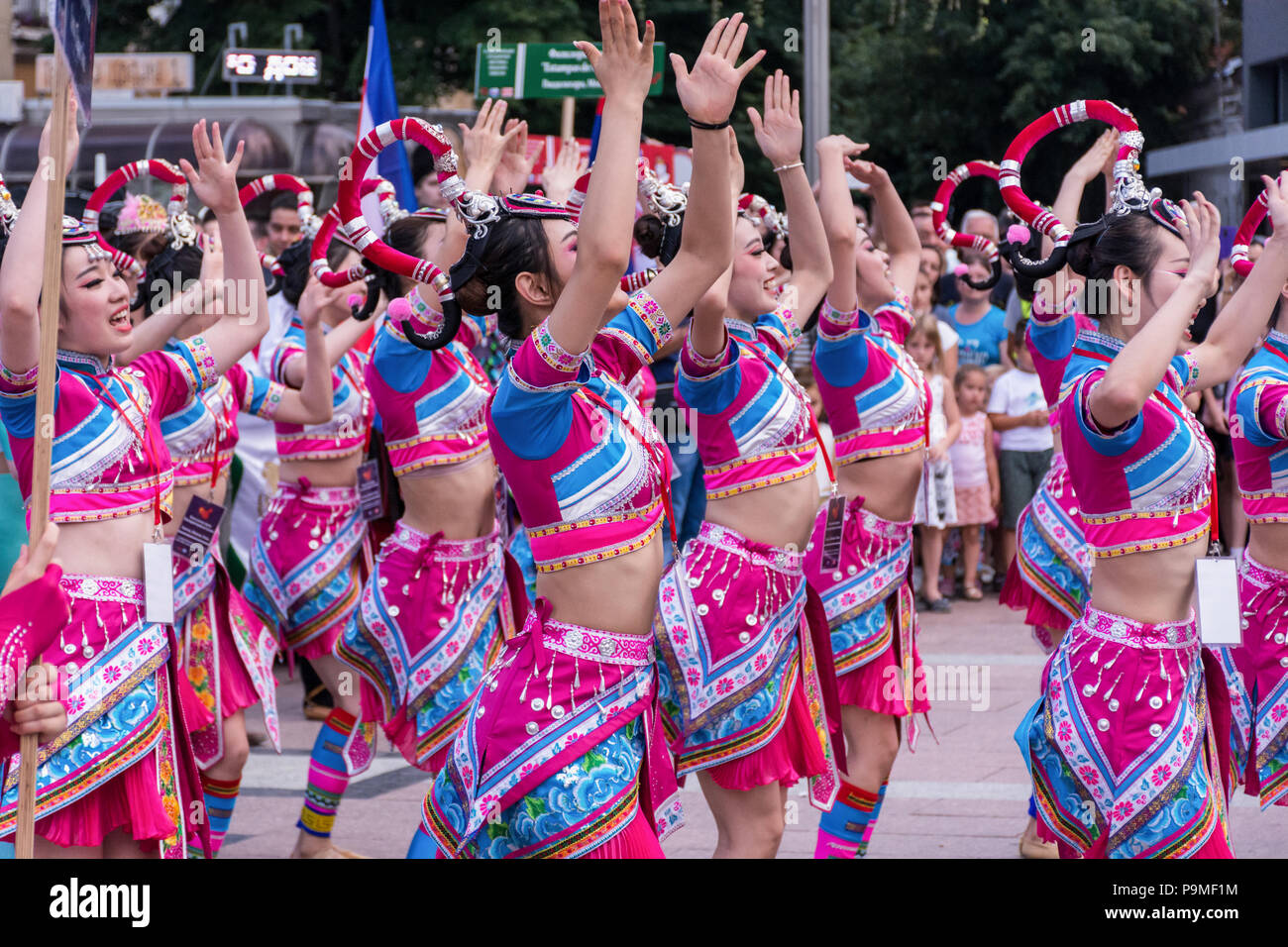 Nis, Serbien - Juli 16, 2018: Chinesische Mädchen tanzen Volkstanz in traditionellen Kostümen auf einem Festival auf dem Platz der Stadt. Close Up, selektiver Fokus Stockfoto