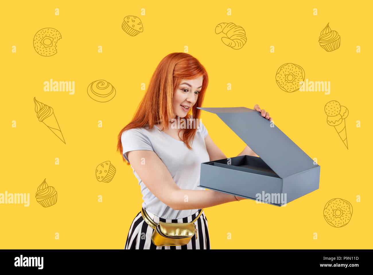 Hungrige student Gefühl überrascht beim Öffnen einer Box mit Donuts Stockfoto