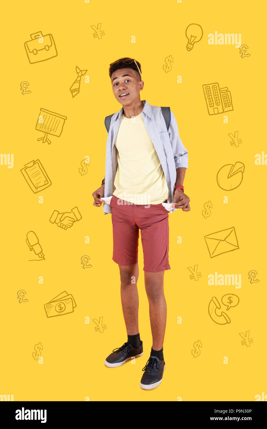 Optimistisch student mit leeren Taschen und lächelnd Stockfoto