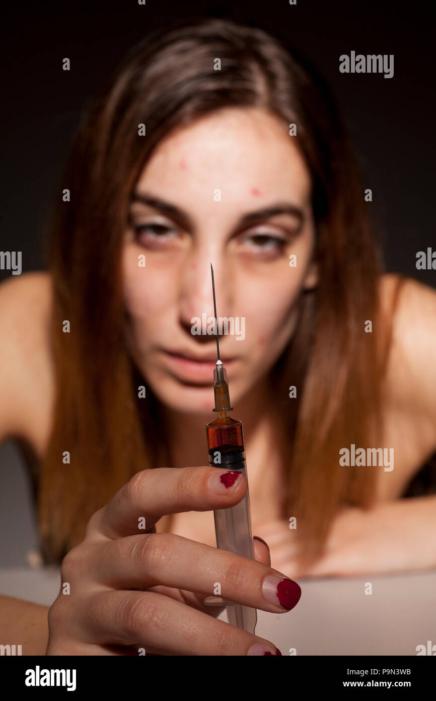 Ein Mädchen mit Spritze und dunkle Ringe um die Augen. Drogensucht Konzept Stockfoto