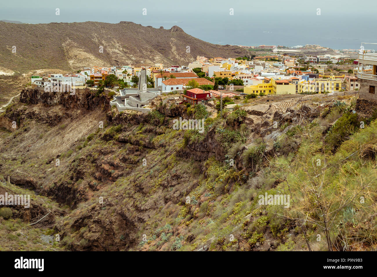 Blick über die Stadt Adeje, Teneriffa, von Barranco del Infierno (Hell's Gorge), die die steile, grüne Tal, helles Gebäude, Atlantik Stockfoto