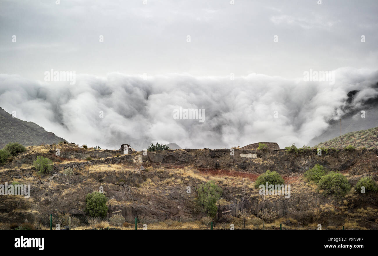 Bemerkenswerte Landschaft ornographic Wasserfall Wolken sich über die leeward Hang der Berge nördlich von Santa Cruz, Teneriffa. Ungewöhnliche Natur. Stockfoto