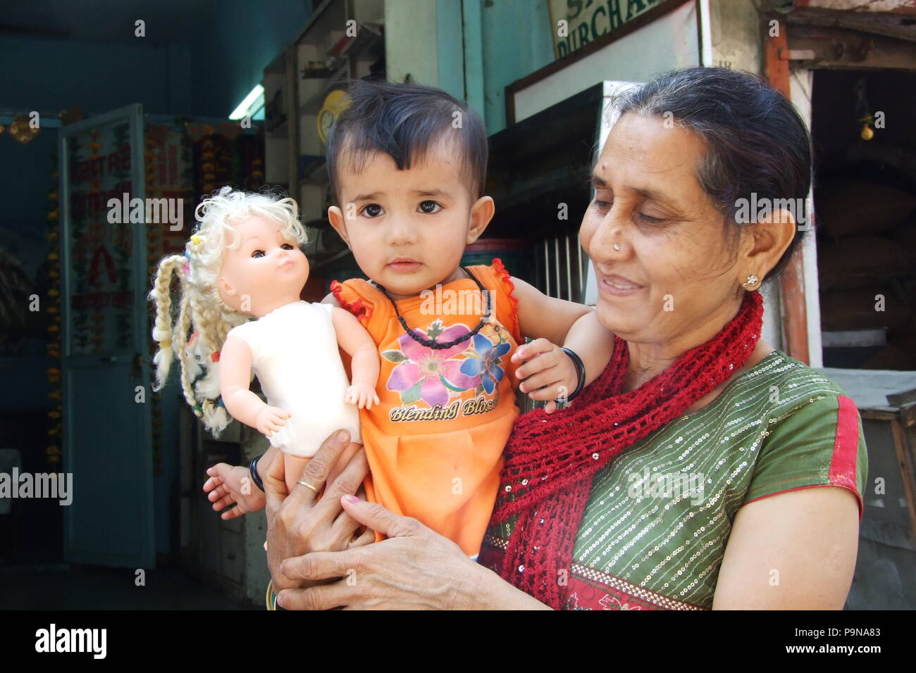 Oma spielt mit ihrer Enkelin und eine Puppe in Neu Delhi Stockfoto
