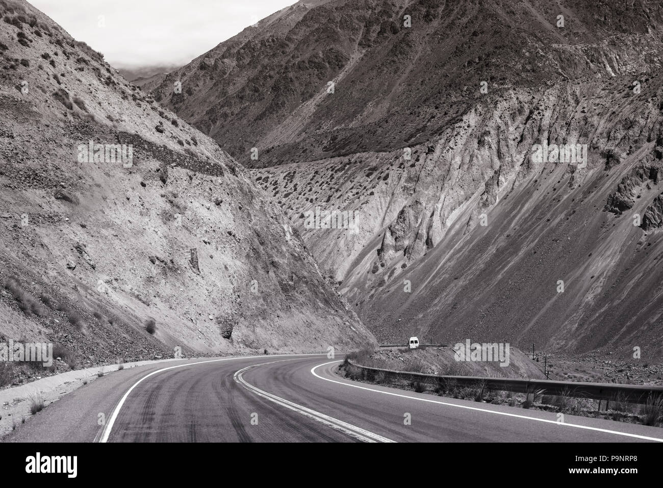 Berg Wüstenlandschaft mit felsigen Hügeln und Auto fahren, einsame Straße von Argentinien, Südamerika in Schwarz und Weiß. Stockfoto