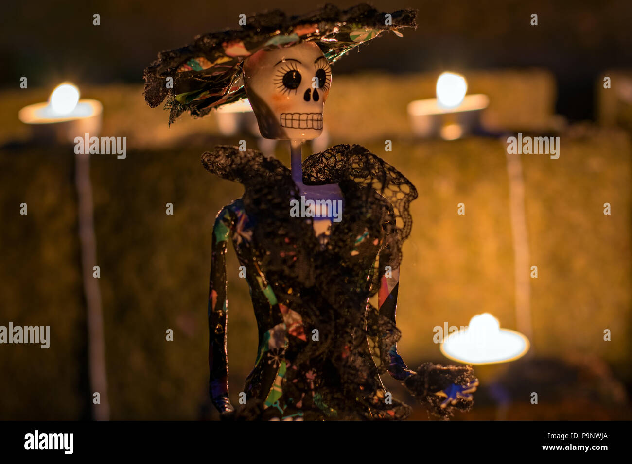 La Calavera Catrina Puppe in der Nacht umgeben von Kerzen für mexikanischen Tag der Toten Stockfoto
