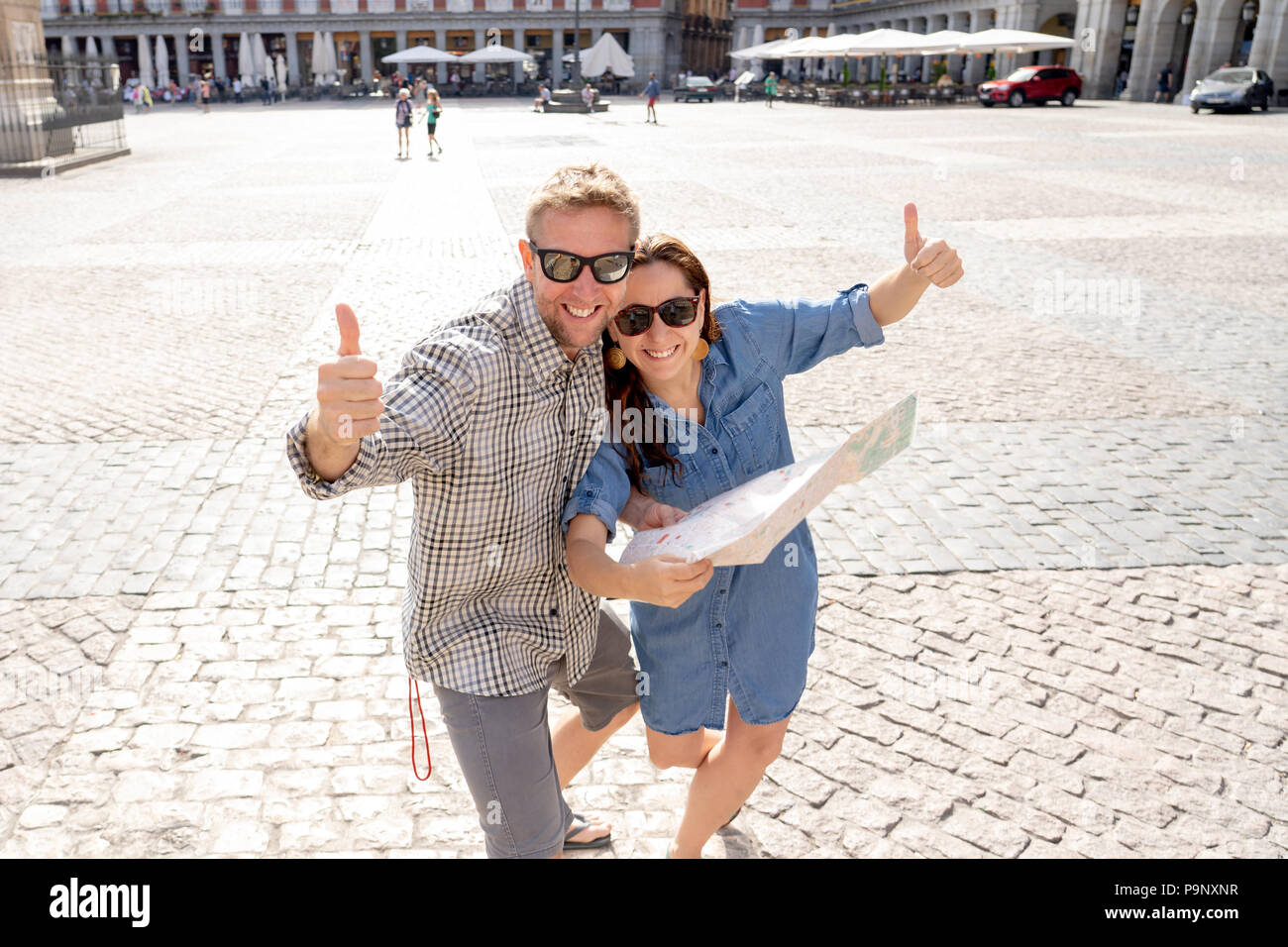 Gerne stilvolle junges Paar auf Sommer Urlaub in Madrid Spanien Suchen nach Wegbeschreibungen auf eine touristische Karte lächelte, als sie eine Karte vom Ehemann statt vergleichen Stockfoto