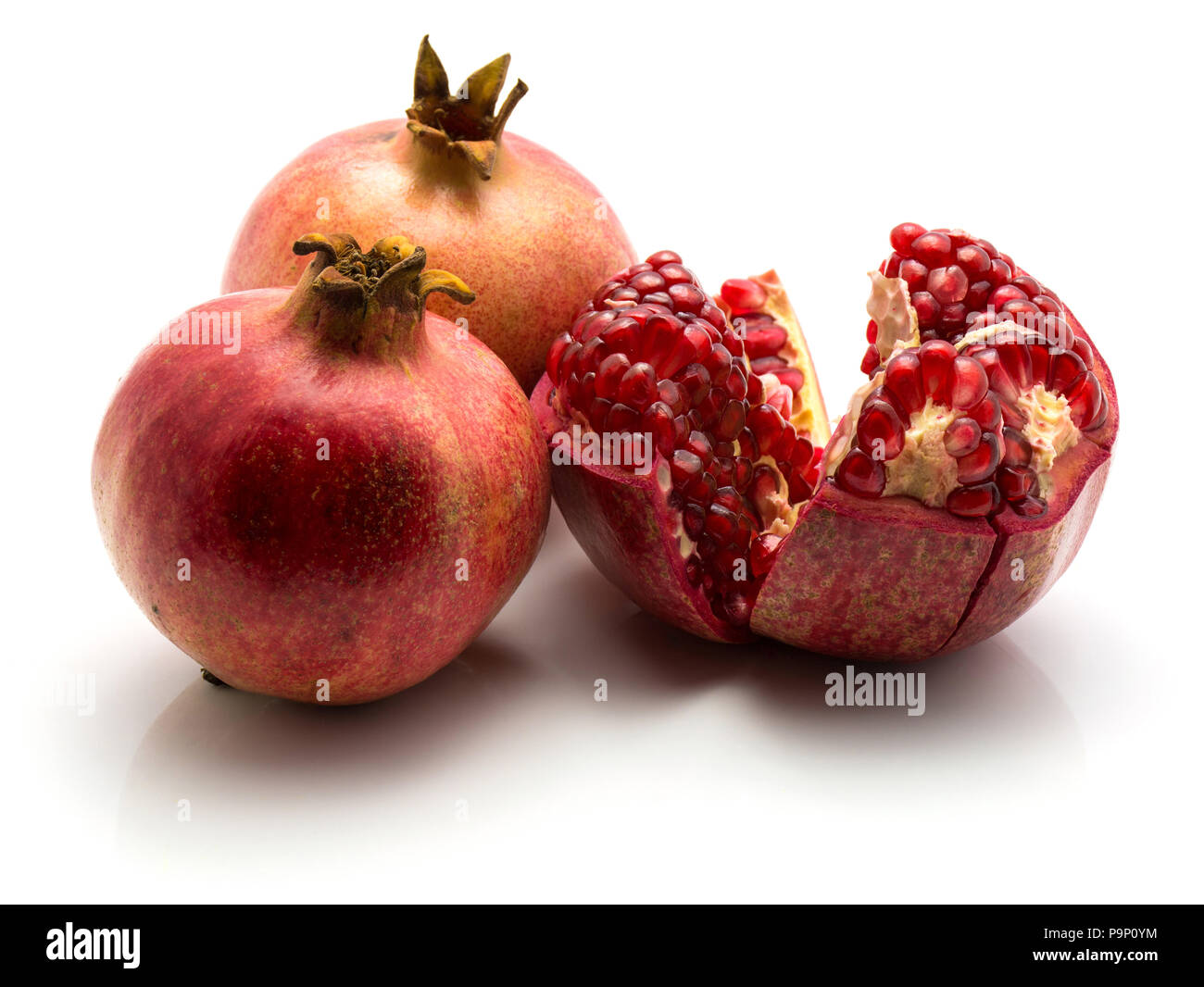 Drei Granatapfel auf weißem Hintergrund zwei ganze eine offene isoliert Stockfoto