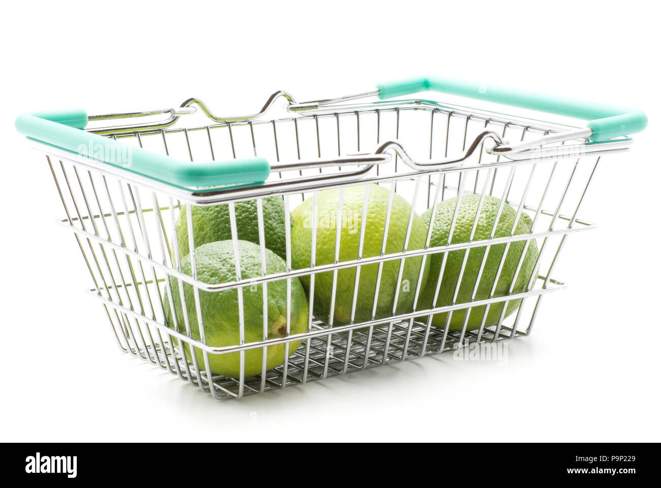 Limes in einem Warenkorb auf weißem Hintergrund Stockfoto